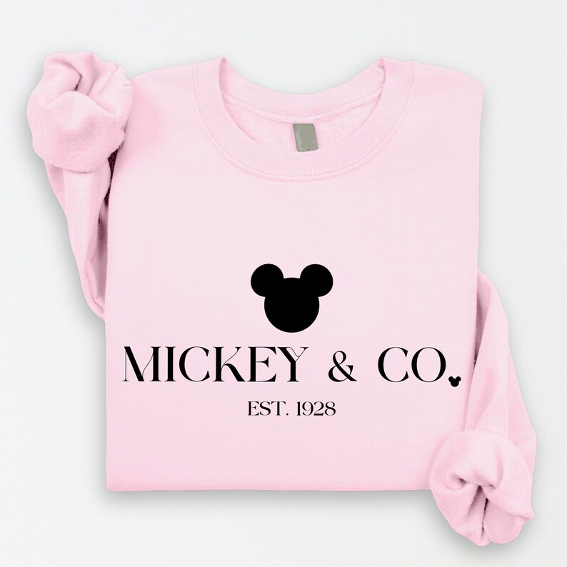 May include: Pink sweatshirt with a black silhouette of Mickey Mouse and the text "MICKEY & CO. EST. 1928"