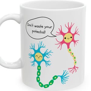 May include: White ceramic mug featuring a cartoon illustration of two neurons with smiling faces. One neuron is blue, the other is pink. A speech bubble above the neurons reads, "Don't waste your potential!"
