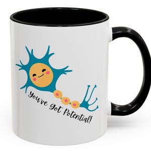 May include: White ceramic mug with a black interior and handle. The mug features a teal neuron illustration with a smiling face and the text "You've got Potential!" in black script. The neuron has a yellow cell body and orange nodes.