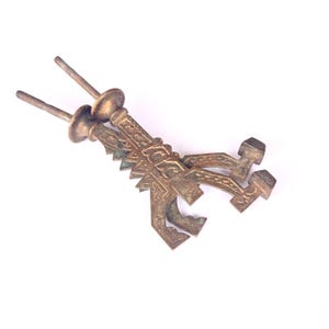 May include: Two ornate, antique, brass keyhole escutcheons with intricate designs. The escutcheons are in a worn, aged condition, with a patina of rust and oxidation.