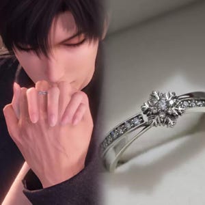 May include: A silver ring with a snowflake design set with small diamonds. The ring is on a white surface.