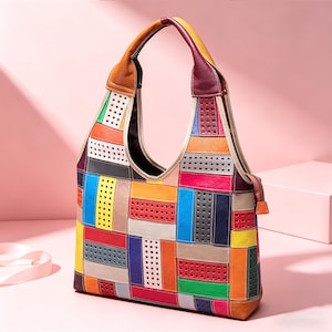 Könnte beinhalten: Eine bunte Patchwork-Schultertasche mit einem großen, gebogenen Griff. Die Tasche hat rechteckige und quadratische Patches in Rot-, Orange-, Gelb-, Grün-, Blau- und Lilatönen. Die Patches haben ein perforiertes Design.
