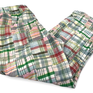 May include: Pants featuring a patchwork design composed of various plaid fabric squares in shades of green, pink, red, blue, and white. The garment has an elasticized waistband and a relaxed fit, constructed from multiple rectangular panels.
