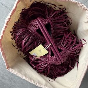 May include: A deep burgundy woven handbag with long, flowing fringe detailing, featuring two integrated handles and a light yellow rectangular tag attached with a string that displays the text RB special for you and a small QR code.