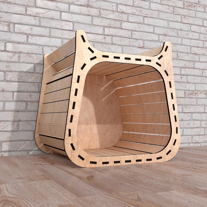 May include: A light-colored wooden storage cube with a curved front and a slatted design. The edges are outlined with a dashed black line. The cube is set against a brick wall and wooden floor.
