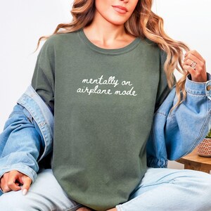 Comfort Colors 1717 t-shirt with the text “Mentally on Airplane Mode”, minimal travel-themed design. Funny airplane mode shirt for travel lovers, airport outfits, vacations, flights, introverts, and everyday casual wear.