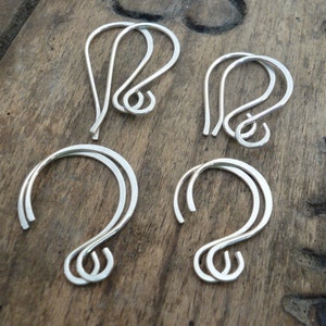 May include: Four pairs of silver-toned earring hooks. The hooks are made of a thin, flexible metal and have a simple, elegant design.