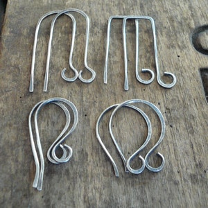 May include: Four pairs of silver earring hooks, two pairs are straight and two pairs are curved.