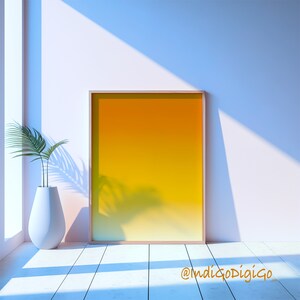 May include: A framed print with a gradient background transitioning from yellow to orange. The print is hanging on a white wall with a potted plant in the foreground.