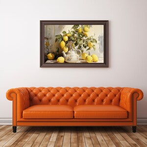 May include: A framed painting of a still life with lemons and a teapot. The lemons are arranged in a bowl and on a table. The teapot is white with blue and gold accents. The painting is set against a white wall and a brown leather sofa.