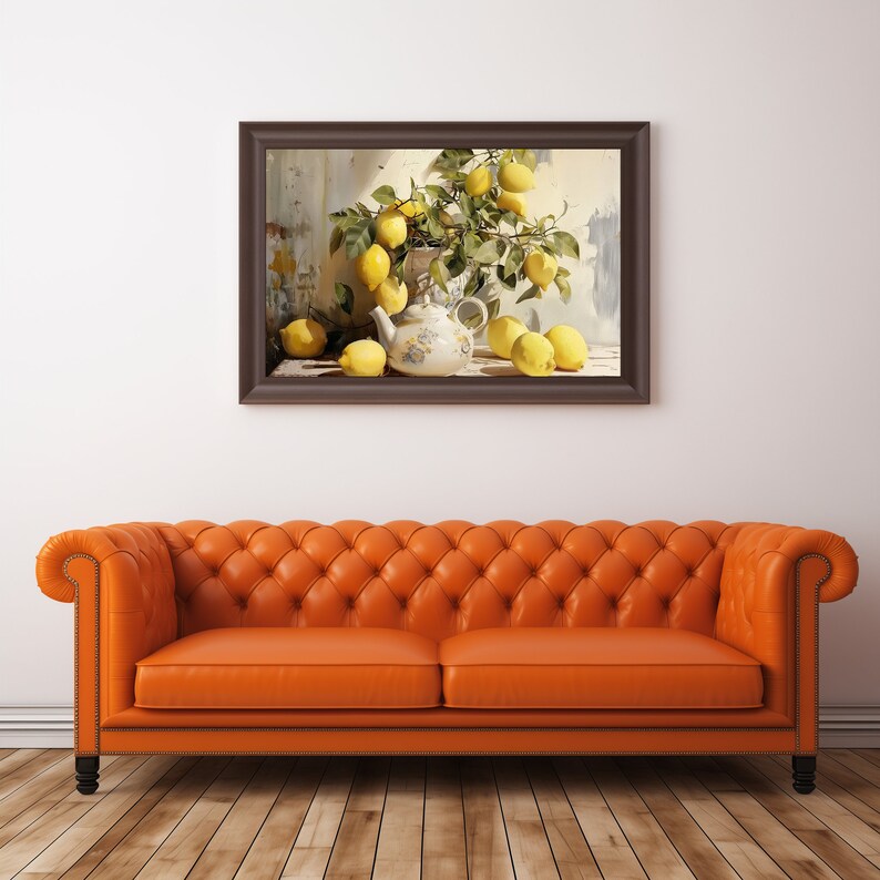 May include: A framed painting of a still life with lemons and a teapot. The lemons are arranged in a bowl and on a table. The teapot is white with blue and gold accents. The painting is set against a white wall and a brown leather sofa.