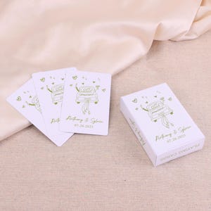 May include: White playing cards and a box with a green illustration of a car with the words "Just Married". The cards and box also include the names "Anthony & Sylvia" and the date "07.20.2025".