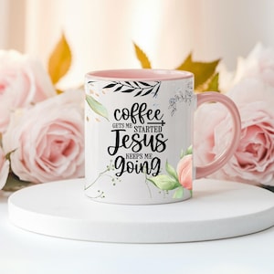 May include: White ceramic coffee mug with a pink interior and handle. The mug features the text "coffee gets me started, Jesus keeps me going" in black script. Floral and leaf designs decorate the mug.