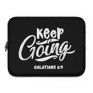Puede incluir: Funda negra para portátil con la frase "Keep Going" en escritura blanca. El texto "Galatians 6:9" está debajo. La funda tiene cierre de cremallera.