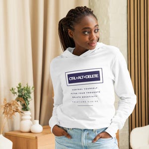 May include: White hoodie with long sleeves. The front displays the text "CTRL+ALT+DELETE" in a navy blue rectangle. Underneath, the hoodie reads "CONTROL YOURSELF, ALTER YOUR THOUGHTS, DELETE NEGATIVITY, GALATIANS 5:22-23".