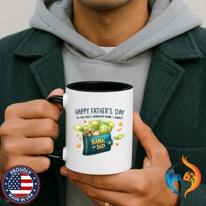 Peut inclure: Mug en céramique blanche avec intérieur et anse noirs. Le mug affiche le texte "HAPPY FATHER'S DAY TO THE MOST GENEROUS BANK I KNOW !" et un dessin d'un portefeuille débordant d'argent et de pièces. Les mots "BANK OF DAD" sont également sur le portefeuille.