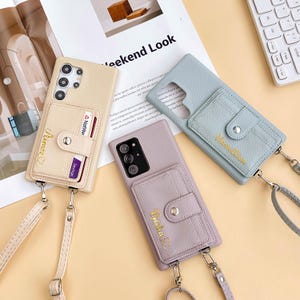 May include: Beige, lavender, and light blue leather phone cases with card holders and wrist straps. Each case has a different name embroidered on the card holder. The cases are designed to fit various phone models.