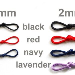 May include: A close-up of elastic cord in four colors: black, red, navy, and lavender. The cord is shown in two sizes: 1 mm and 2 mm.