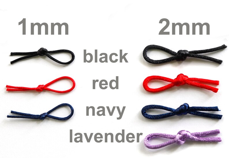 May include: A close-up of elastic cord in four colors: black, red, navy, and lavender. The cord is shown in two sizes: 1 mm and 2 mm.