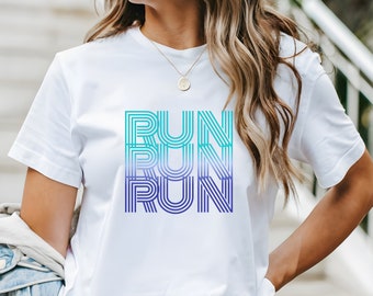 May include: White t-shirt with the word "RUN" in a gradient of teal to purple. The word is stacked three times. The shirt has short sleeves and a crew neck.