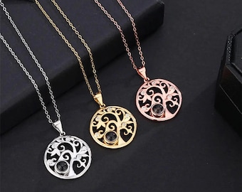May include: Three necklaces with circular pendants. The pendants feature a tree of life design with a black center stone and small clear stones. The necklaces are silver, gold, and rose gold in color, each with a matching chain.