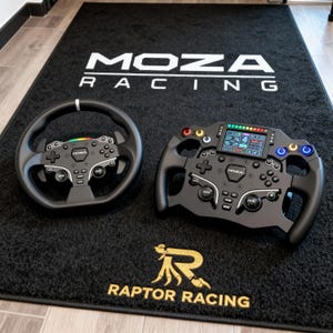 Puede incluir: Dos volantes de carreras negros con botones y controles se muestran sobre una alfombra negra. La alfombra tiene el texto blanco "MOZA RACING" y "RAPTOR RACING" en dorado. Los volantes están diseñados para un simulador de carreras.