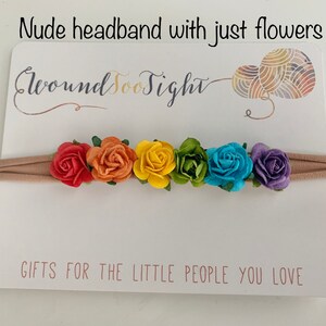 K&ouml;nnte beinhalten: Ein nacktes Stirnband mit einem Regenbogen aus Stoffblumen. Das Stirnband befindet sich auf einer wei&szlig;en Karte mit dem Text "Around Too Sight" und "Gifts for the little people you love".