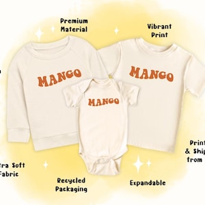 May include: Three cream-coloured shirts with the word "MANGO" printed in orange on each. The shirts are a long-sleeved sweatshirt, a short-sleeved t-shirt, and a bodysuit.