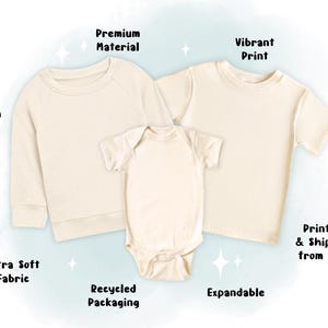 May include: Cream-colored baby and toddler clothing set. The set includes a long-sleeve sweatshirt, a short-sleeve t-shirt, and a onesie. The image highlights the features: 100% cotton, ultra-soft fabric, premium material, vibrant print, expandable, and recycled packaging.
