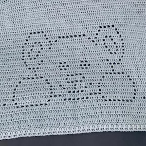 May include: A light grey crocheted blanket with a decorative pattern of a zig-zag design.