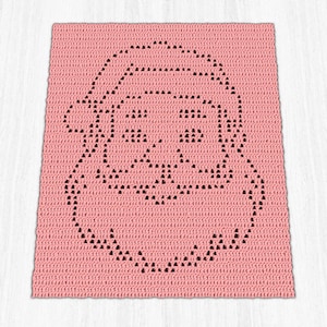 May include: A rectangular crochet blanket in a soft pink hue featuring a black outline of a Santa Claus face. The design is created using a series of individual stitches that form the shape of a bearded figure wearing a hat, centered on the fabric.