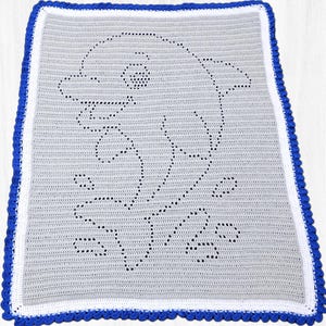 May include: A crocheted blanket featuring a dolphin design. The blanket is primarily gray with a white border and a blue scalloped edge. The dolphin is outlined in black, with details like the eye and bubbles.