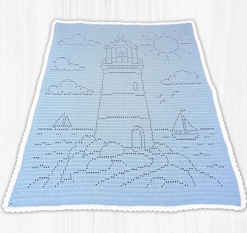 May include: A light blue crochet blanket featuring a white scalloped border and a central lighthouse design. The pattern includes a sun, clouds, and two sailboats on the water, all created using a filet crochet technique with open stitches.