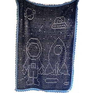 May include: A blue crocheted blanket with a white crocheted design. The blanket has a blue crocheted border.