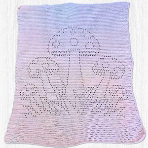 Può includere: Una coperta all'uncinetto con una combinazione di colori sfumati, che va dal rosa chiaro al blu. La coperta presenta un design dettagliato di funghi in una tonalità più scura, con tre grandi funghi e piccoli dettagli.