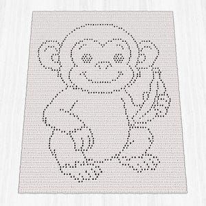 May include: A crocheted white blanket featuring a black outline of a cartoon monkey holding a banana. The monkey has a smiling face and large ears. The blanket is rectangular and appears to be handmade.