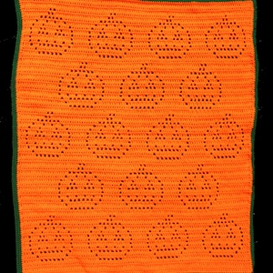 May include: An orange crochet blanket featuring a repeating pattern of jack-o'-lantern faces. The blanket has a green border. The jack-o'-lanterns are created with open spaces in the crochet work. This handmade blanket is perfect for Halloween.
