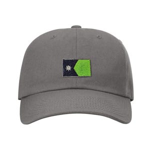 May include: A gray baseball cap with an embroidered green, black, and white flag design.