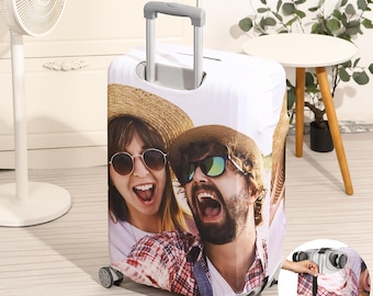 May include: White suitcase cover with a photo of a couple smiling and wearing sunglasses. The couple is wearing hats and casual clothing. The suitcase cover has a zipper and a handle.