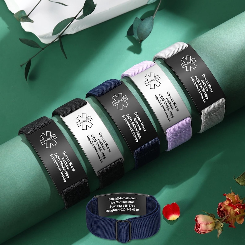 May include: Medical alert bracelets in black, white, navy, lavender, and gray. Each bracelet features a metal plate with a medical symbol and the text "Devon Black, Asthma, DOB 09/09/1999, Equipment Inside." A navy blue bracelet with contact information is also shown.
