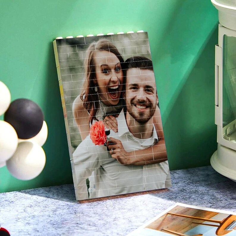 Peut inclure: Une mosa&iuml;que de photos d'un couple, un homme et une femme, souriant et regardant la cam&eacute;ra. La femme tient une fleur rouge. La photo est imprim&eacute;e sur un fond blanc.