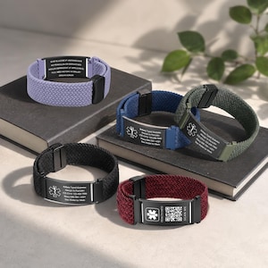 Peut inclure: Cinq bracelets d'alerte médicale avec des bandes élastiques tressées en lavande, bleu, vert foncé, noir et bordeaux. Chacun comporte une plaque métallique rectangulaire noire, affichant un symbole d'étoile médicale blanc, du texte et un QR code.