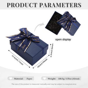 May include: A navy blue gift box with a gold ribbon and bow. The box is 5.71 inches long, 3.94 inches wide, and 2.56 inches tall. The box is made of paper and weighs 3.55 ounces.