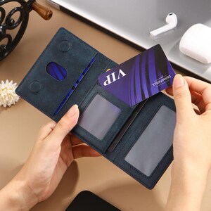 May include: A blue leather wallet with multiple card slots and a clear ID window. The wallet is open and a VIP card is visible inside.