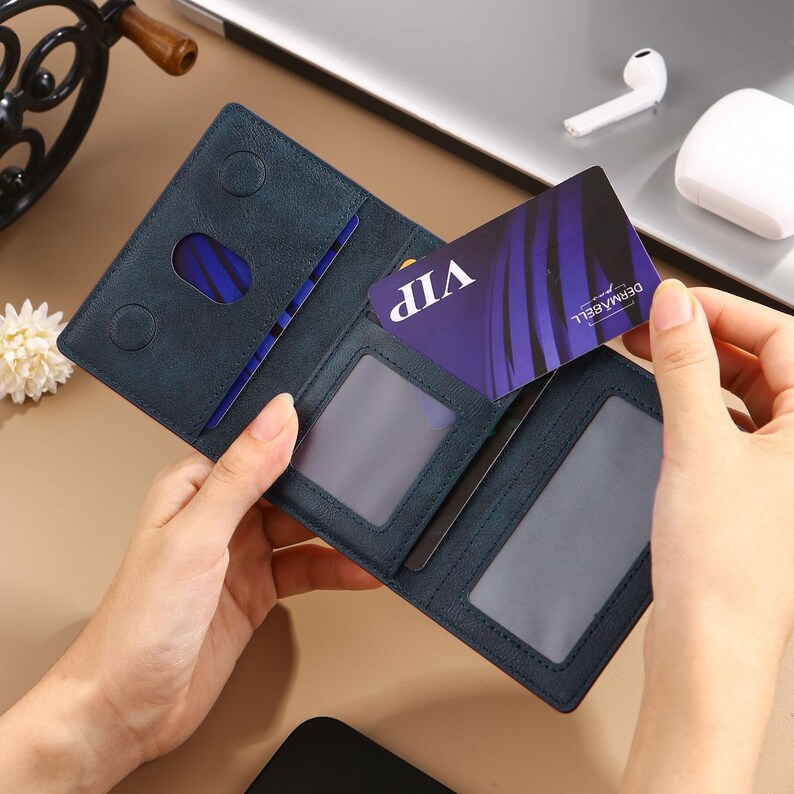 May include: A blue leather wallet with multiple card slots and a clear ID window. The wallet is open and a VIP card is visible inside.