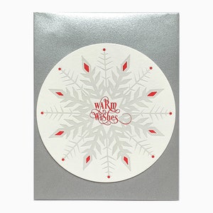 Tarjeta circular de copo de nieve con cálidos deseos impresos