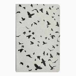 May include: A gray notebook cover with a repeating pattern of black crow silhouettes.