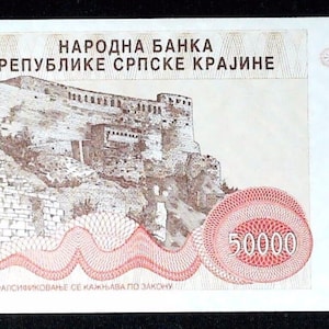 Puede incluir: Un billete de 50000 dinares de la República Serbia de Krajina, fechado en 1993. El billete presenta una ilustración central de una fortaleza de piedra, complejos patrones guilloché rojos, el texto "НАРОДНА БАНКА РЕПУБЛИКЕ СРПСКЕ КРАЈИНЕ" y una firma.