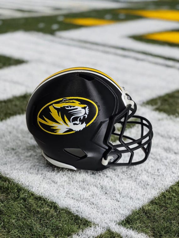 black football helmet leaning on a white football helmet Mizzou Football Helmet Miniature Model - 3d Printed