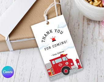 May include: A white gift tag with the text "THANK YOU FOR COMING!" and a red fire engine illustration. The tag includes the name "Gabriel" and a red siren graphic. The tag is tied to a brown gift box with a white ribbon.